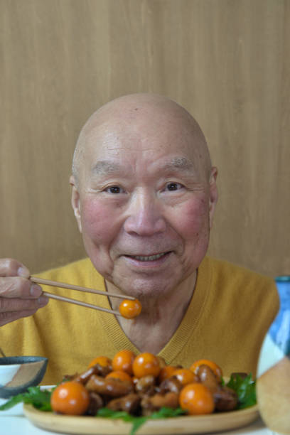 istock A smiling elderly man enjoying stewed chicken offal and sake 2204418680