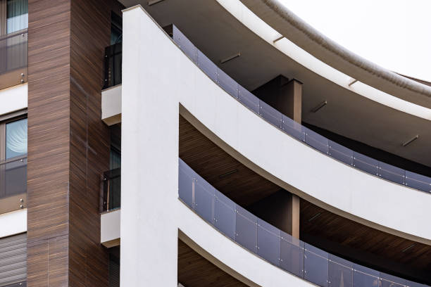 A captivating close-up of a uniquely designed oval-shaped residential building in Antalya, Turkey, featuring vibrant orange balconies. This high-quality architectural shot is perfect for real estate marketing, construction companies, architect studios, and design inspirations. Ideal for showcasing modern urban housing, building aesthetics, and innovative architectural elements.