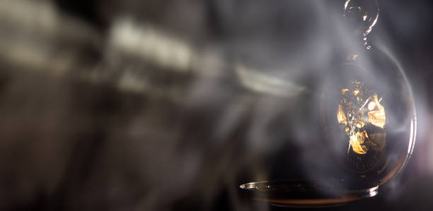 istock Antique clock, a beautiful antique clock being pierced by rays of light highlighted by smoke, selective focus. 2204422068