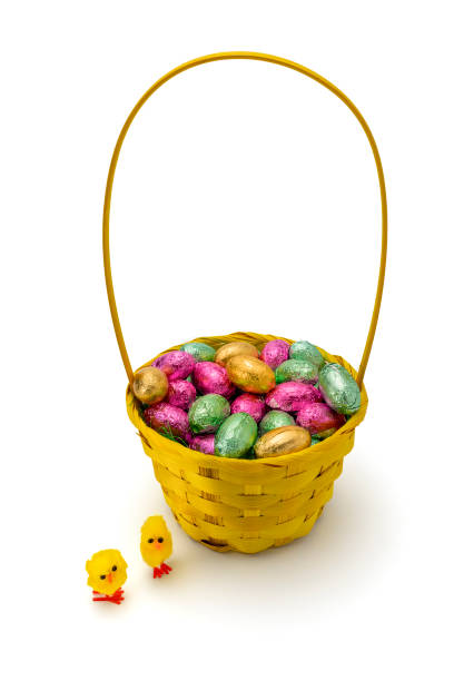 istock Yellow Wicker Easter Basket with Foil Wrapped Chocolate Eggs Isolated on White Background 2204426844