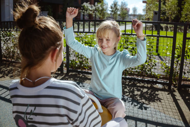istock Two children playing together at a park on a sunny day 2204427248
