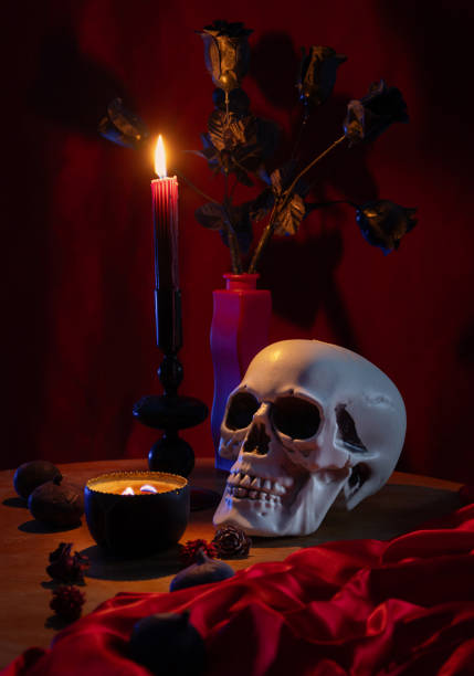 scull and burning candles on dark red background