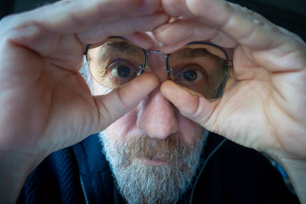 Senior man looking through finger glasses. People.