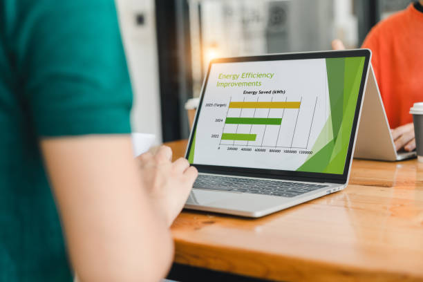 istock person working on laptop displaying bar chart about energy efficiency improvements, with focus on energy saved in kilowatt hours, in modern office 2204441708