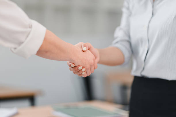 istock close up of two people shaking hands in professional setting, symbolizing agreement, partnership, or collaboration. background is blurred, emphasizing handshake 2204443193