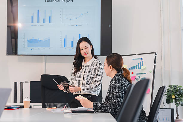 istock Businesswomen discussing financial reports in modern office setting 2204449114