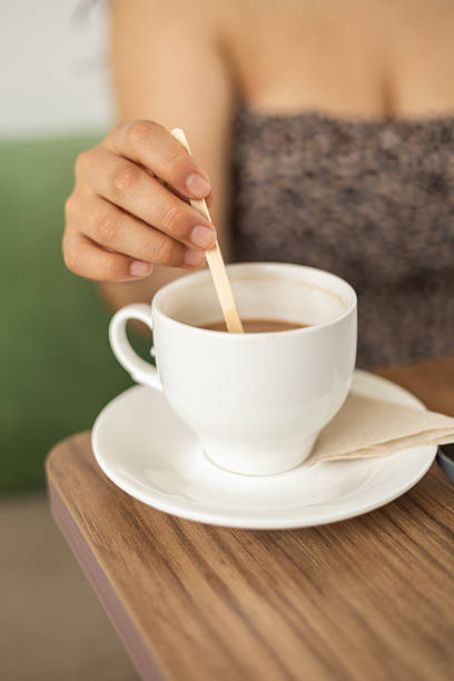 istock Girl Stirring Her Coffee in a Cup 2204449739