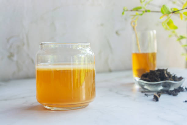 istock a jar of Jun tea fermented probiotic drink made from green tea and honey on white table. 2204459814