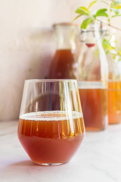 a glass of black tea kombucha fermented probiotic drink on white table.