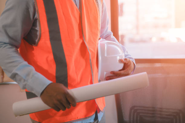 istock An engineer or foreman working on site holding hardhat and blueprint, Engineer architect planning on blueprints construction 2204470365