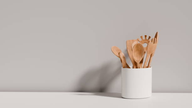 istock collection of wooden kitchen utensils is neatly arranged in a white container on a table. light gray wall enhances the simplicity and elegance of the setup. 3d render 2204470717