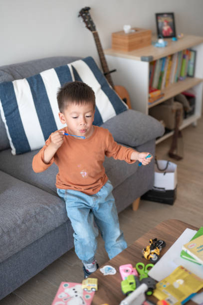 istock Child Playing with Soap Bubbles in a Cozy Living Room 2204470762