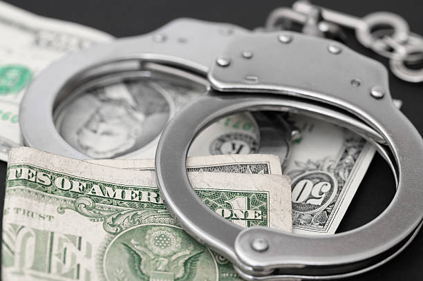 istock Metal handcuffs lying on dollar bills, cash prison system, 2204471104