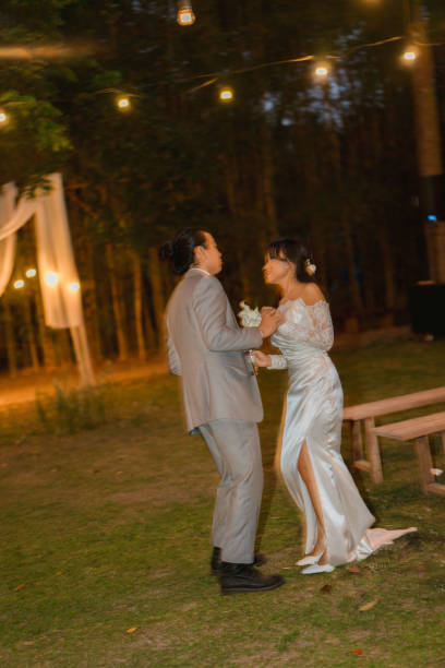 istock Asian Couple Wedding Dance Under Romantic Evening Lights Outdoors at Night 2204472123