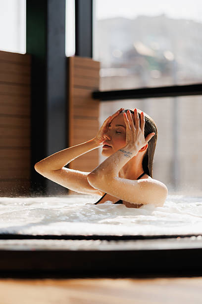 istock Pretty woman sitting in hot tub in spa complex 2204473681