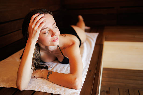 istock Relaxed woman in bikini lying on bench in sauna 2204473931