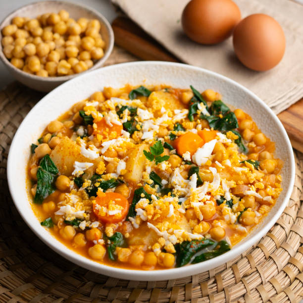 Delicious stew of potatoes and chickpeas stewed with spinach, vegetables and boiled egg. Traditional Spanish recipe..