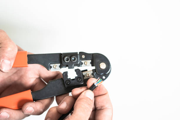 istock The mechanic strips and connects the wires to the network using special tools. 2204476274