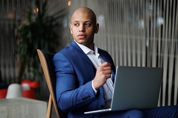 istock African american businessman using laptop in hotel lobby 2204476704