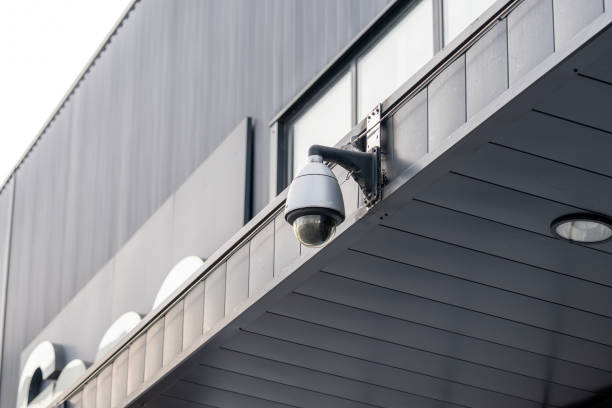 istock Surveillance camera observing modern architecture in an urban setting during daylight 2204478980