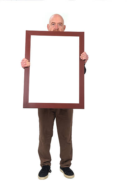 man carrying objects on white background Front view of a man holding a blank frame on white background. person holding frame over face stock pictures, royalty-free photos & images