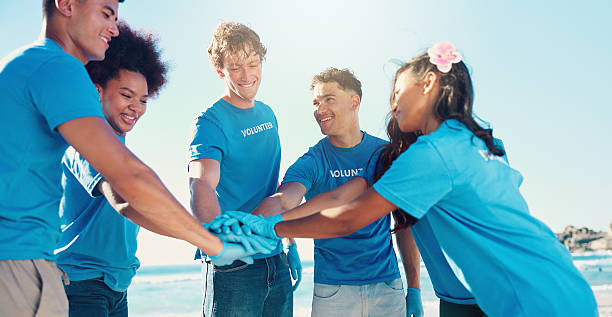 istock Beach, volunteer and people with hands together for teamwork, support and community service. Climate change, recycling and friends in circle for ocean clean up, collaboration or social responsibility 2204484382