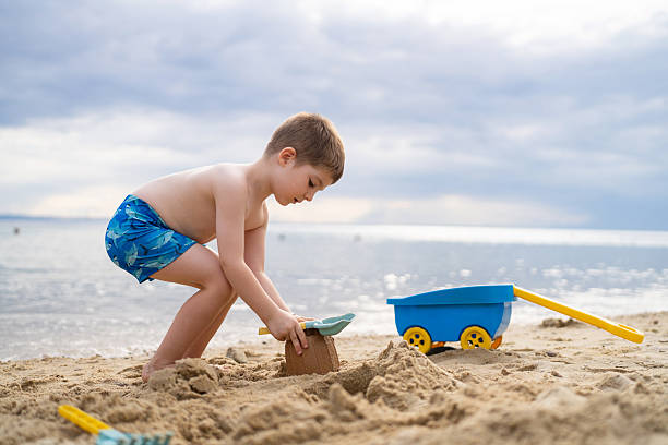 Little boy playing in the sand on the beach.
