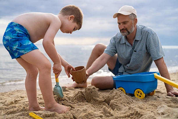 istock Father and son playing in the sand on the beach 2204486008