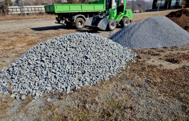 construction is dependent on the transport and movement of materials. hand dump for park construction. loader and container truck during park construction. piles of granite aggregates