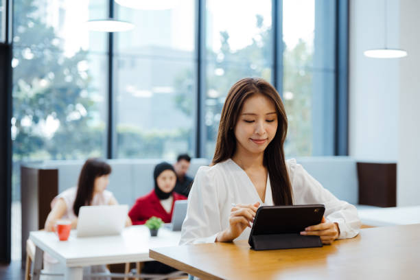 istock Asian businesswoman working with digital tablet in office 2204487668