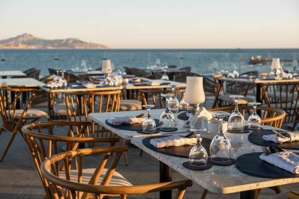 istock Sunset dining by the sea with elegantly set tables and glassware, creating 2204488299