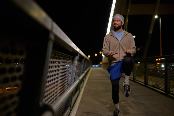 istock Young sportsman warming up on a bridge at night 2204488436