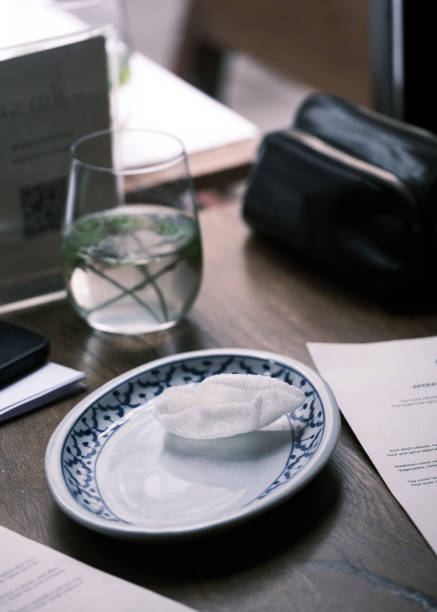 Elegant restaurant table setting with a traditional blue-patterned plate, a glass of infused water, and a napkin, fine dining ambiance, cozy cafe atmosphere