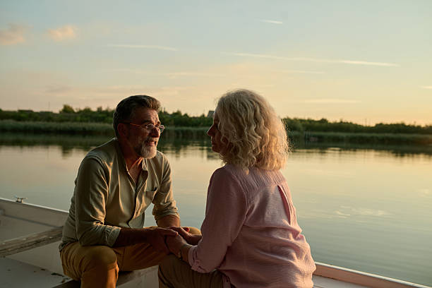 istock Senior couple holding hands and talking on a boat at sunset 2204491604