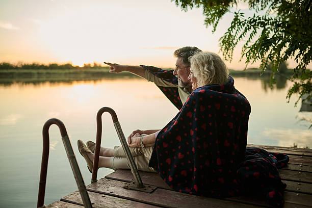 istock Senior couple enjoying sunset on lake 2204491617
