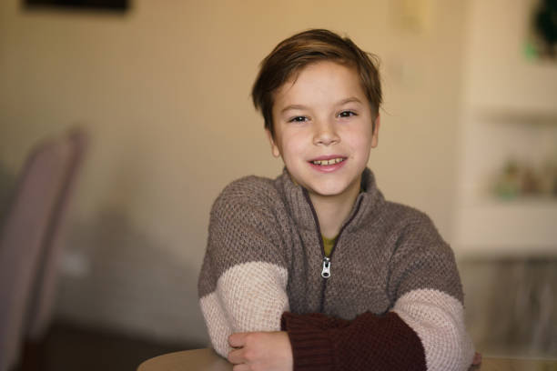 Portrait of a happy boy looking at camera while sitting at home