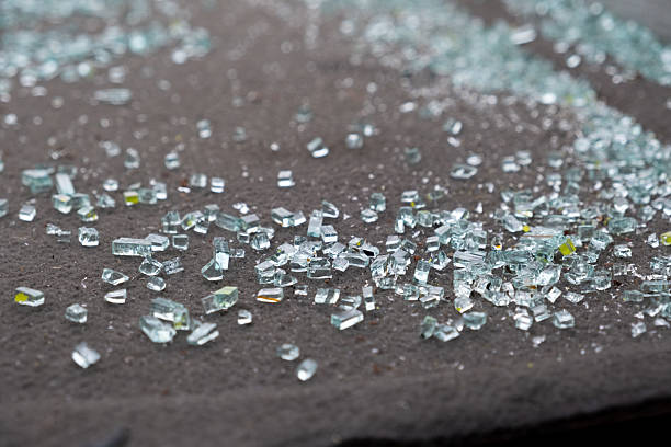 istock Scattered Fragments of Shattered Glass Resting on a Dark Surface, Reflecting Light and Creating Intriguing Patterns 2204494295