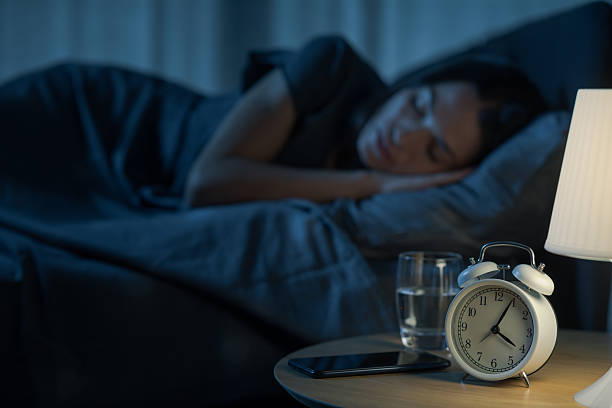 istock Young relaxed woman sleeping in bed 2204495033