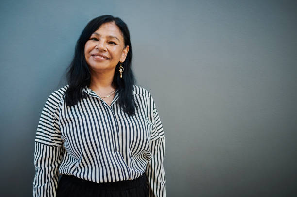 istock Confident Middle-Aged Woman Smiling Against Blue Background 2204501298