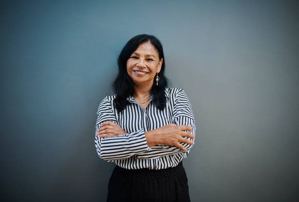 istock Confident Middle-Aged Woman Smiling Against Blue Background 2204501307