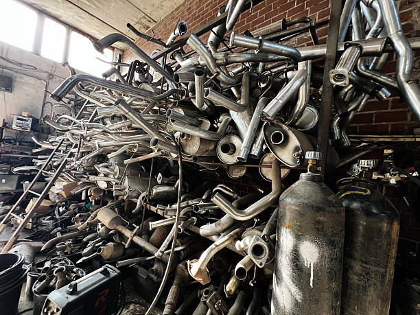 A stockpile of automotive exhaust parts in an industrial repair shop environment.