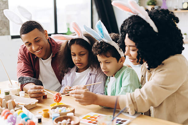 istock Happy family painting easter eggs wearing bunny ears 2204502913