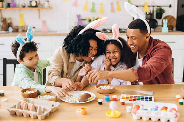 istock Happy family decorating easter eggs, wearing bunny ears 2204502947