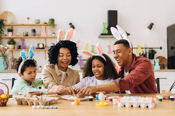 istock Happy family painting easter eggs wearing bunny ears 2204502951