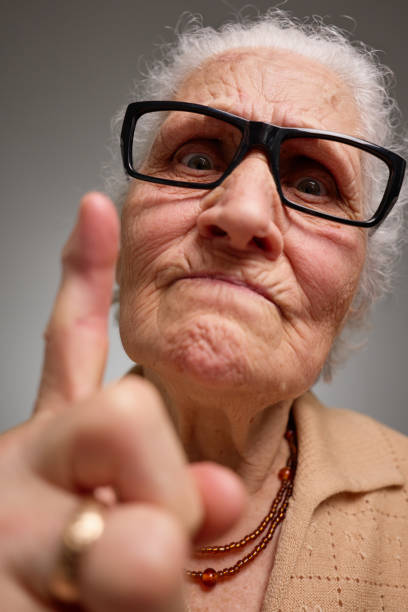 istock Grumpy old woman looking nervous, skeptical and displeased on a gray background 2204504566