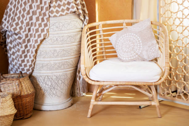 istock A wicker chair with a cushion next to a vase makes a cozy spot 2204504663
