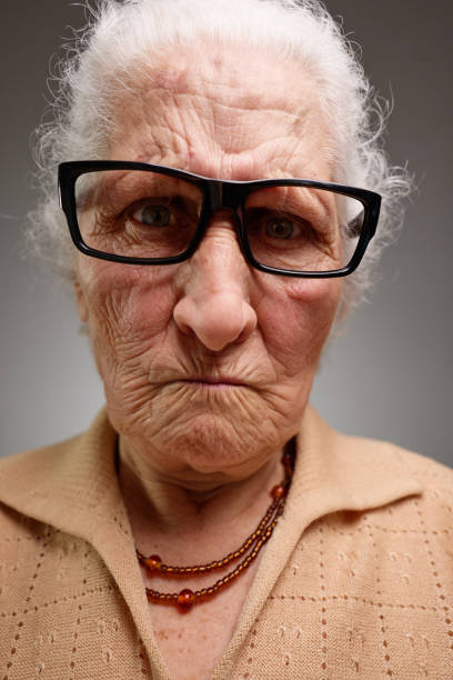 istock Grumpy old woman looking nervous, skeptical and displeased on a gray background 2204505119