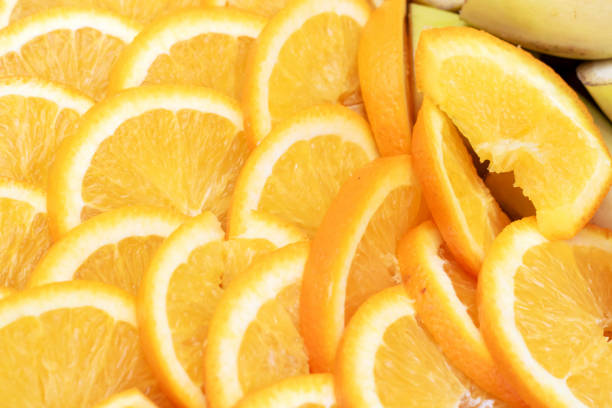 A mix of citrus fruits including sliced oranges, clementines, and Rangpur surrounded by a banana in the background. A colorful display of natural foods rich in Vitamin C