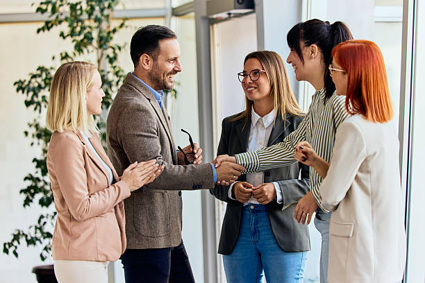 istock Group of Business Professionals Shaking Hands in a Corporate Office Setting 2204505431
