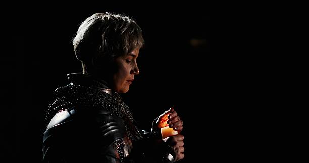 istock A contemplative figure gracefully holding a candle in a dark and mysterious setting 2204506212